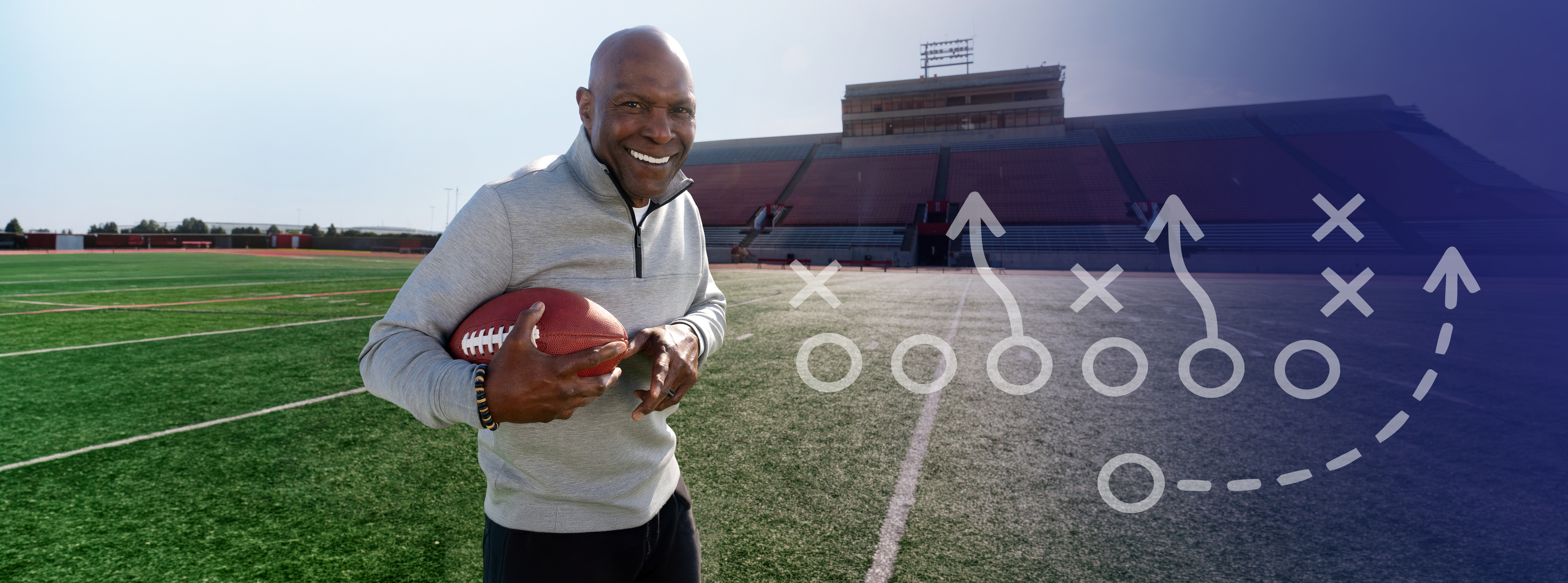 Former professional football player Pete Shaw holding a football on a football field
